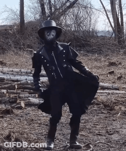 Person In Mask And Hat In Log Field GIF