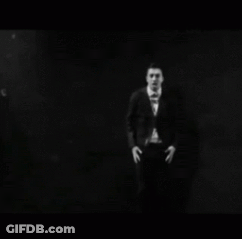 Person In Mask Making Heart Hands At Microphone GIF