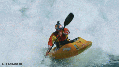Person In Orange And Yellow Kayak Going Through Wave GIF