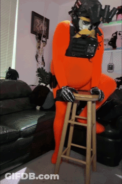Person In Orange Costume Sitting On Stool GIF
