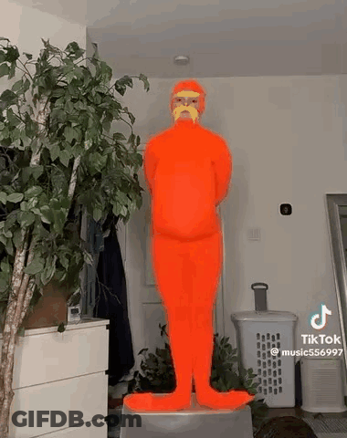 Person In Orange Costume With Mustache On Stool GIF