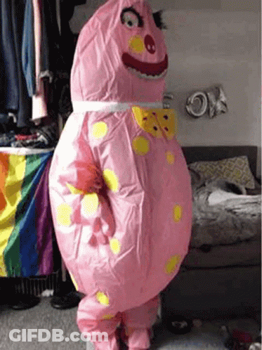 Person In Pink Inflatable Costume In Bedroom GIF