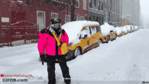 Person In Pink Jacket In Front Of Snow-Covered Taxi Cabs GIF
