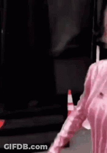 Person In Pink Shirt Next To Traffic Cone GIF