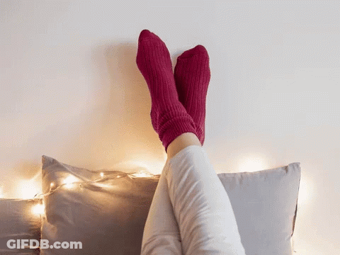 Person In Pink Socks Sitting On Bed GIF