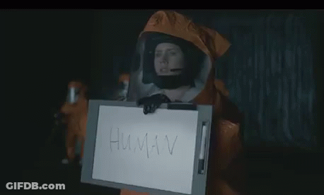 Person In Protective Suit Holding Sign Saying Human GIF