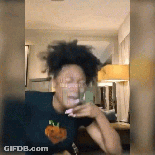 Person In Pumpkin Shirt Looking At Phone GIF