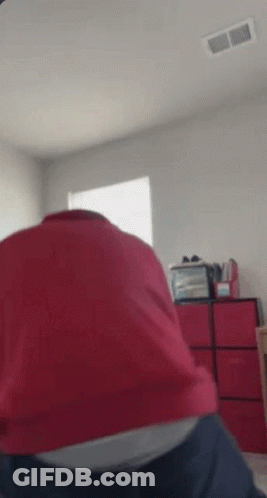 Person In Red Shirt Sitting On Bed With Red Drawers GIF