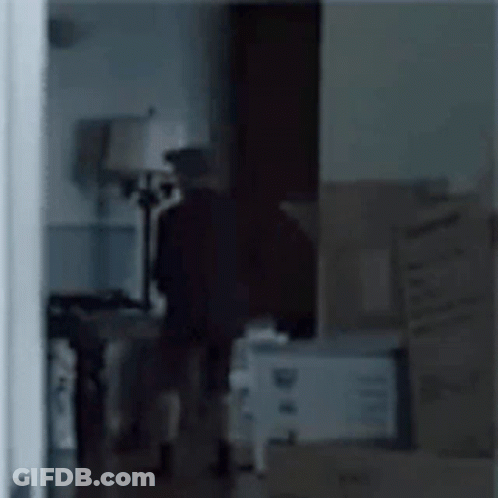 Person In Room With Boxes And Lamp GIF