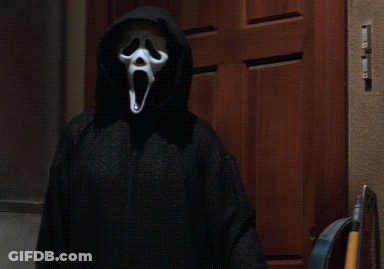 Person In Scream Mask Standing By Wooden Door GIF