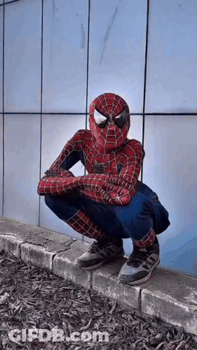 Person In Spiderman Costume Squatting On Sidewalk GIF