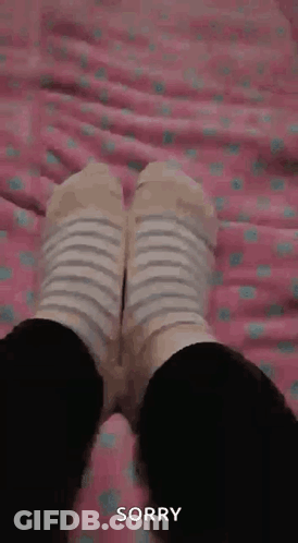Person In Striped Socks Lying On Bed Sorry GIF