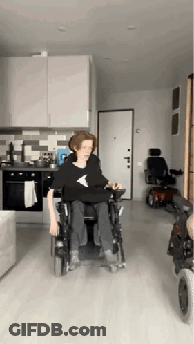 Person In Wheelchair In Kitchen With Scooter GIF