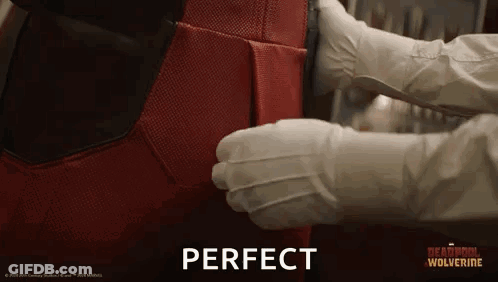Person In White Gloves Holding Red Superhero Suit GIF