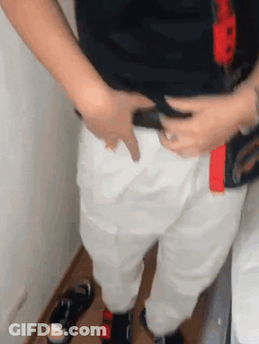 Person In White Pants And Black Shirt Holding Belt GIF