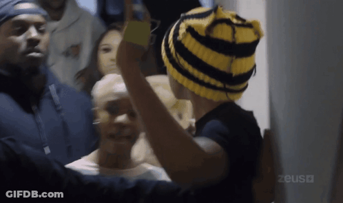 Person In Yellow And Black Striped Hat With Zeus GIF