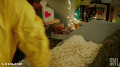 Person In Yellow Jacket Next To Bed GIF