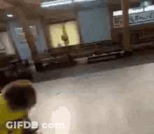 Person In Yellow Jacket Standing In Room GIF