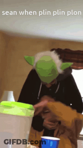Person In Yoda Hat Holding Blue Cup GIF