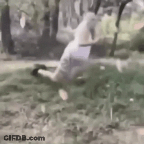 Person Kneeling In Grass With Knife GIF