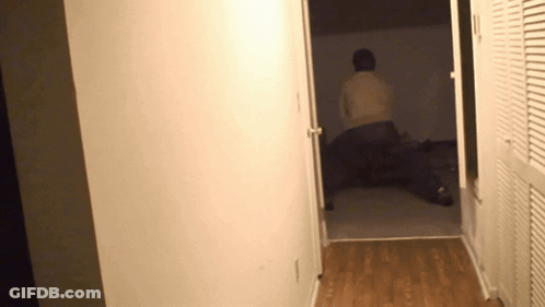 Person Laying On Bed In Hallway GIF