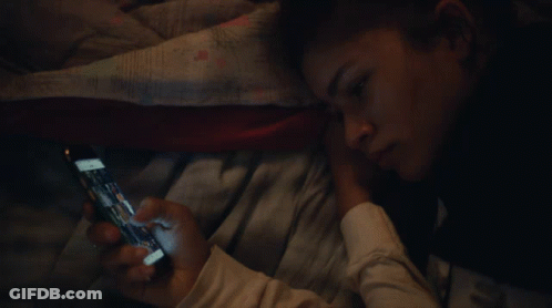 Person Laying On Bed Looking At Phone GIF