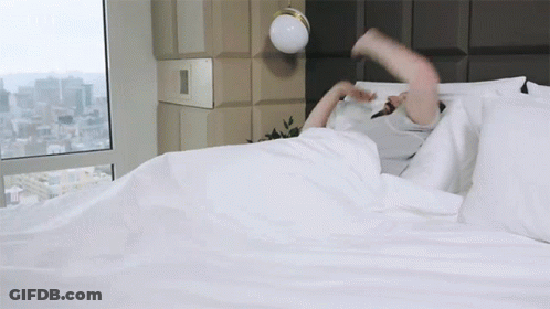 Person Laying On Bed With City View GIF