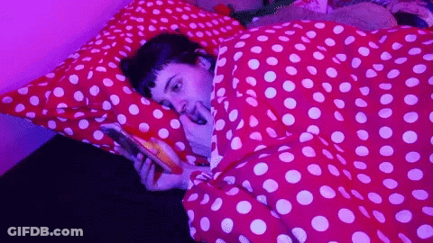Person Laying On Bed With Polka Dot Blanket GIF