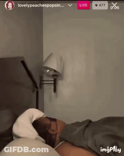 Person Laying On Bed With Wall Lamp GIF