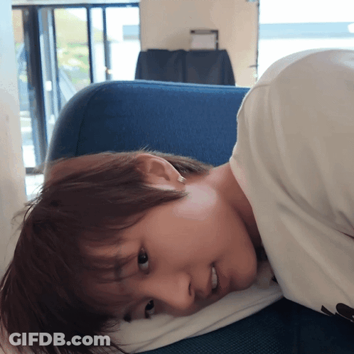 Person Laying On Blue Couch With Pillow GIF