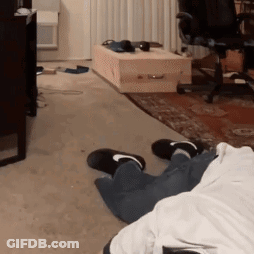 Person Laying On Living Room Floor With Coffin GIF