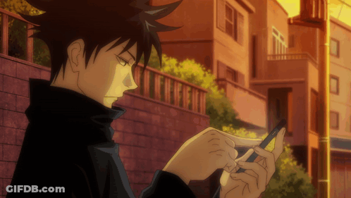 Person Looking At Cell Phone In Front Of Brick Wall GIF
