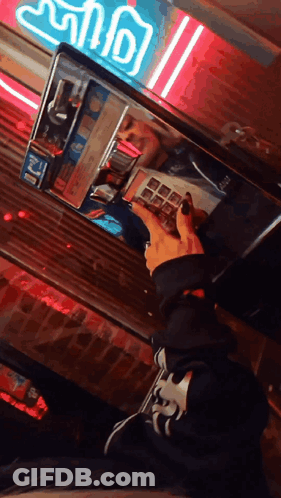 Person Looking At Reflection In Mirror With Neon Ice Cream Sign GIF