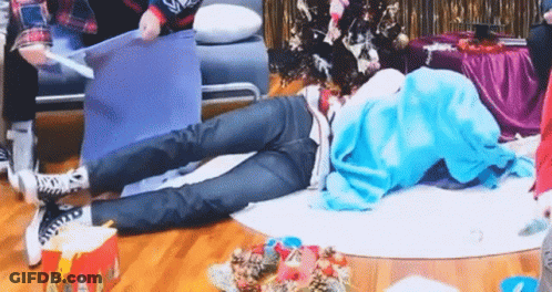 Person Lying Cross-Legged Near Christmas Tree GIF