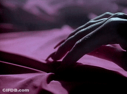 Person Lying On Bed With Pink Sheet GIF