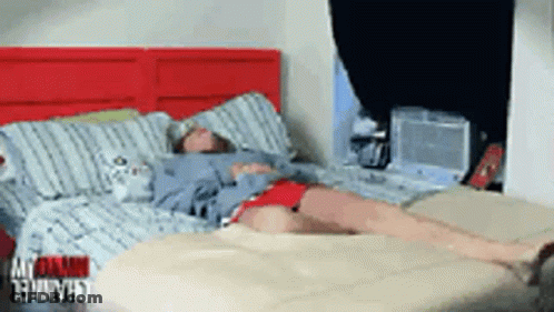 Person Lying On Bed With Red Headboard GIF