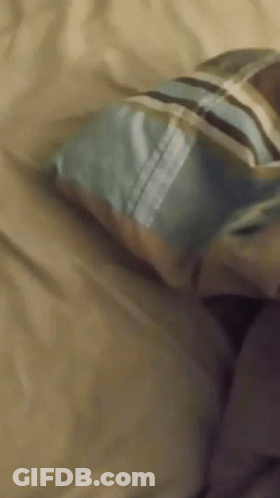 Person Lying On Bed With Striped Pillow GIF