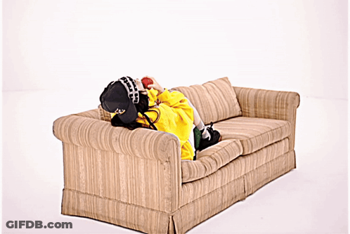 Person Lying On Couch In Yellow Jacket And Hat GIF