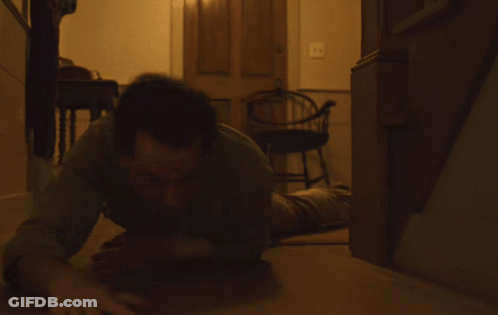 Person Lying On Wooden Floor With Arms Outstretched GIF