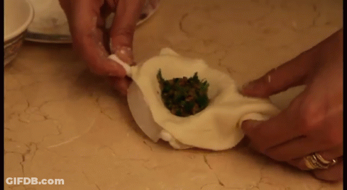 Person Making Dumpling With Ring On Left Hand GIF