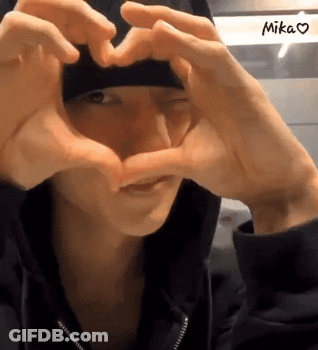 Person Making Heart Shape With Hands Saying Mika GIF