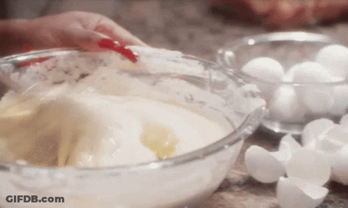 Person Mixing Ingredients In Glass Bowl With Eggs GIF
