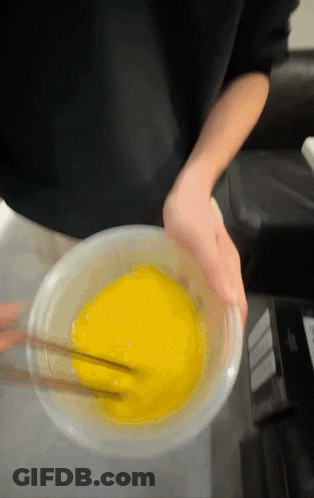 Person Mixing Yellow Liquid With Chopsticks In Bowl GIF