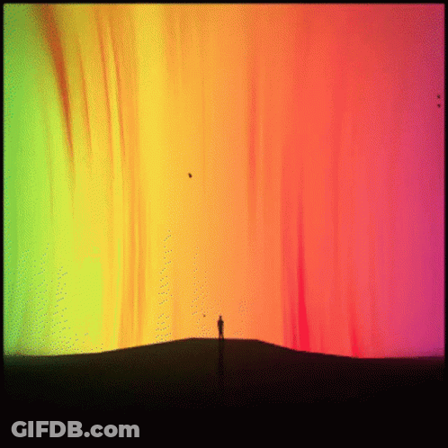 Person On Hill In Front Of Rainbow Sky GIF
