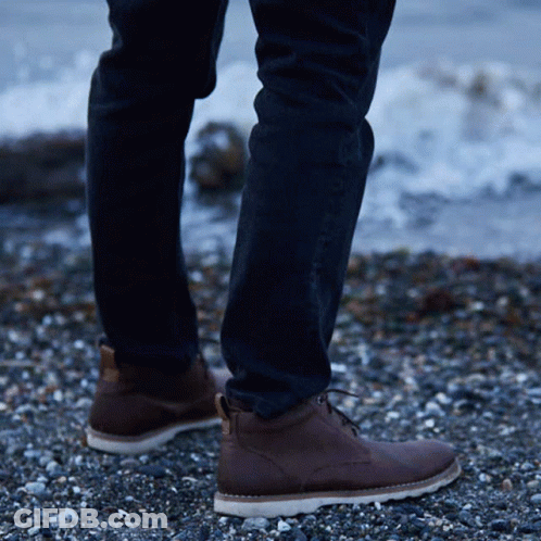 Person On Rocky Beach In Brown Boots GIF