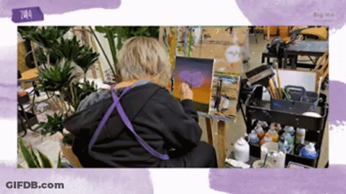 Person Painting On Easel In Purple Apron GIF