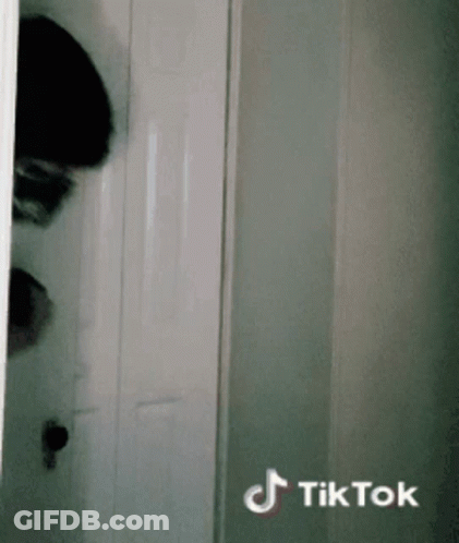 Person Peeking From Behind Door With TikTok Watermark GIF