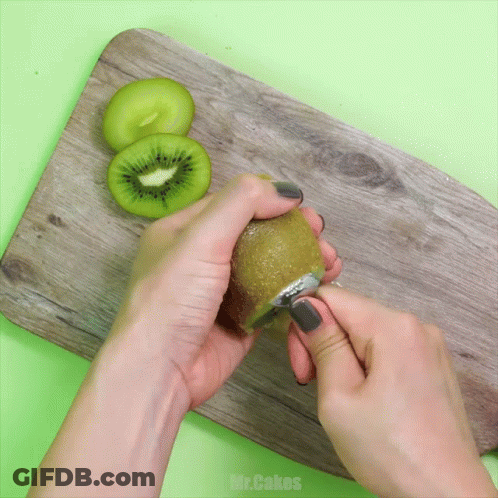 Person Peeling Kiwi On Wooden Board With Mr.Cakes GIF