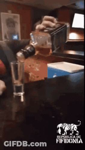 Person Pouring Drink Into Glass With Republica De Fifidonia Logo GIF