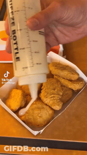 Person Pouring Sauce Into Chicken Nuggets GIF